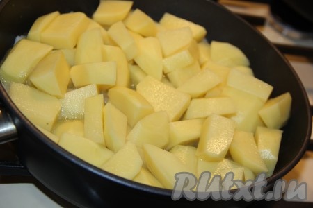 Картофель нарезать средними дольками и добавить в сковороду к луку.
