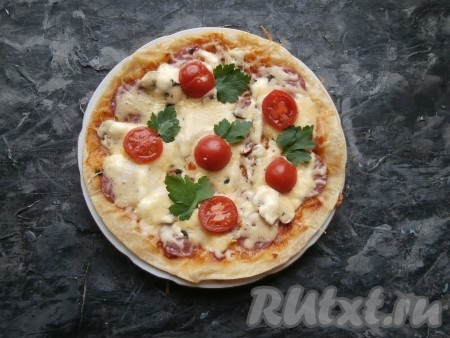 Украсить пиццу зеленью.