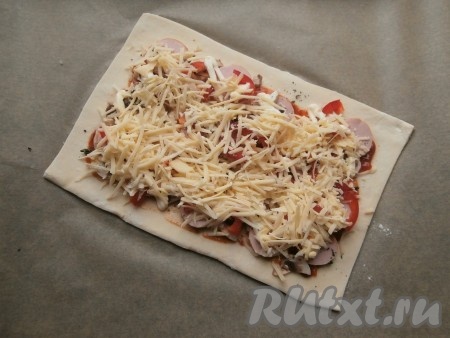 Далее посыпать начинку натёртым на средней тёрке сыром.