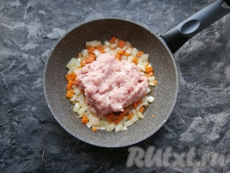 Обжарить морковку с луком, помешивая, 2-3 минуты на среднем огне, затем добавить к ним фарш.
