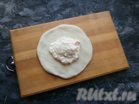 Далее 6 шариков теста на присыпанной мукой поверхности раскатать в лепёшки диаметром 12-13 см. В середину каждой из этих лепёшек выложить по 1-2 столовых ложек творожной начинки.