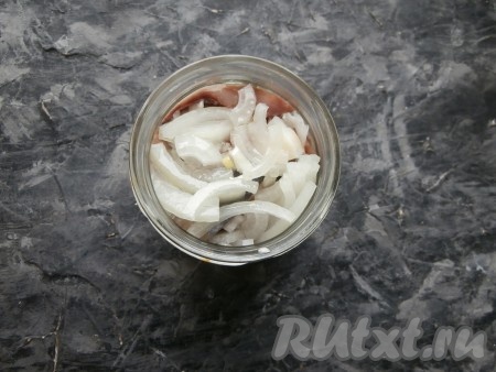 Далее снова выложить часть нарезанного лука и несколько кусочков селёдки. Таким образом разместить в банке весь лук и всю сельдь, чередуя их. Залить содержимое банки подсолнечным маслом.