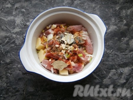 Выложить нарезанные репчатый и зелёный лук, добавить лавровый лист и нарезанный кусочками чеснок, всыпать соль, специи, сушёную зелень, паприку. 