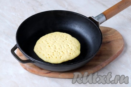 Сухую сковороду разогрейте, по центру выложите две столовые ложки теста, сформировав круглую лепёшку. Тесто размазывать не нужно, оно растечётся самостоятельно, можно только немного подправить края. 