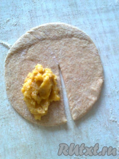 С одной стороны лепёшки от центра вниз сделать ножом надрез, выложить вдоль разреза часть начинки.
