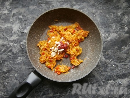 Перемешать и на небольшом огне, часто помешивая, протушить овощи до мягкости (ещё 5-6 минут). Затем добавить томатную пасту и мелко нарезанный чеснок.
