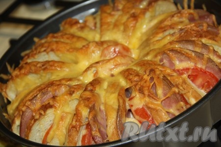 Запекать пирог из батона с колбасой и сыром в разогретой духовке минут 30 (до золотистого цвета) при температуре 200 градусов.
