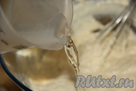 Влить в тесто тонкой струйкой кипяток, смешанный с содой, постоянно перемешивая венчиком.