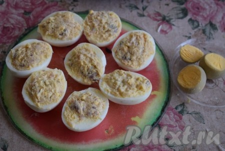 Далее берём половинки белка и обильно наполняем их начинкой из скумбрии и желтков, заполняя не только углубление, но и покрывая всю поверхность белка.
