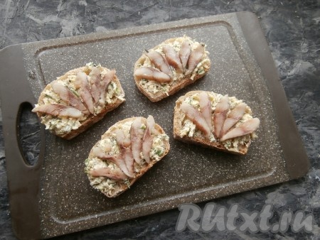 Чёрный хлеб намазать полученной массой, сверху выложить кусочки селёдки.
