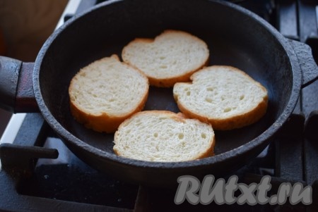 Обжарим багет на сухой сковороде, для этого разогреваем сковороду на среднем огне и выкладываем кусочки багета. Жарим кусочки до подрумянивания сначала с одной стороны (примерно, 2-3 минуты).
