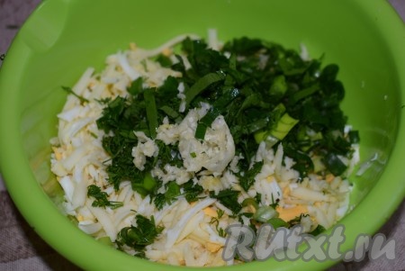 Зелень нарезаем мелко и добавляем к сыру и яйцам. Оставшийся зубчик чеснока очищаем от кожицы и пропускаем его через пресс в миску к сырно-яичной начинке.