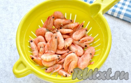Замороженные креветки переложить в дуршлаг и хорошо промыть под холодной водой. Оставить креветки в дуршлаге на 10 минут, чтобы вода полностью стекла.
