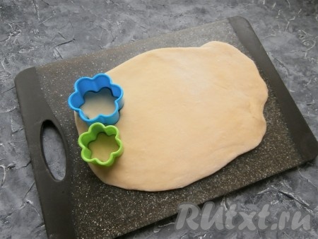 Тесто на припылённой мукой поверхности раскатать в пласт толщиной около 0,5 см. Подготовить формочки в виде цветочков одинаковой формы, но разных размеров (одна - чуть больше, другая - чуть меньше).
