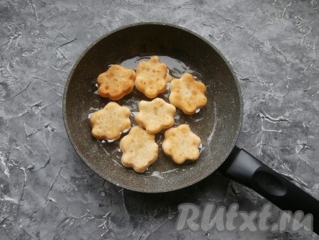 Когда снизу пончики станут румяными, перевернуть их и зарумянить с другой стороны. При этом меньшие цветочки должны распахнуться и раскрыться. Жарятся пончики быстро.
