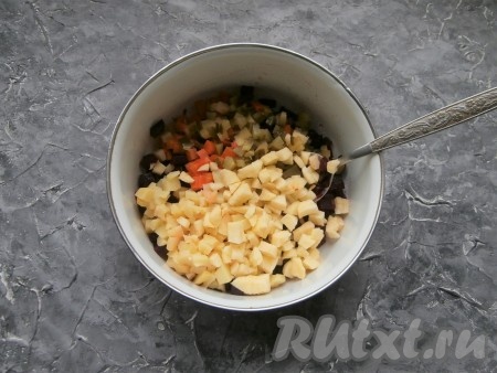 Яблоко очистить от кожуры и семян, нарезать кубиками, сбрызнуть лимонным соком и добавить в миску с нарезанными овощами.
