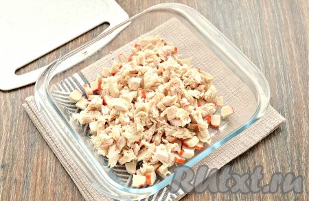 Остывшее куриное филе нарезать небольшими кусочками и выложить к крабовым палочкам.
