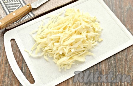 Я готовила постные щи, но вместо воды можно взять такой же объём мясного бульона и сварить щи на бульоне. Налить, примерно, 1,7 литра воды в кастрюлю, поставить на огонь. Когда вода закипит, выложить в неё тонко нарезанную свежую белокочанную капусту, снова дать закипеть. Убавить огонь после закипания и варить капусту 10 минут.
