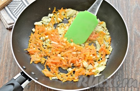 В сковороде разогреть растительное масло, отправить в него морковку и лук, обжарить 3 минуты на среднем огне, периодически перемешивая.
