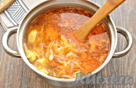 Когда капуста проварится минут 10, в кастрюлю добавить овощи, обжаренные с томатной пастой и солёным огурцом. Посолить щи по вкусу и приправить чёрным молотым перцем, дать закипеть, а после этого варить на небольшом огне ещё 5-7 минут.
