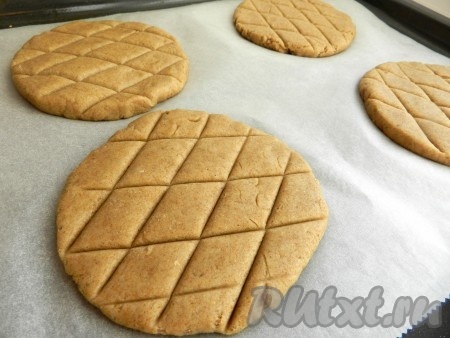 Раскатать тесто в круглые лепешки диаметром примерно 10-11 см, выложить на противень, застеленный бумагой для выпечки. На поверхности ржаных лепешек сделать насечки в виде сеточки. Смазать ржаные лепешки яйцом.  Выпекать лепешки в разогретой до 200 градусов духовке 25-30 минут.