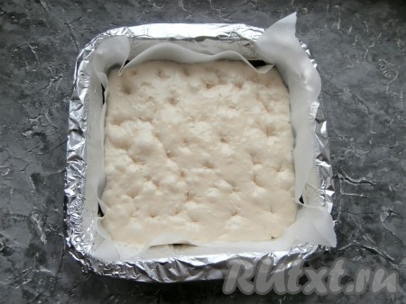 Смазать пальцы небольшим количеством оливкового масла и сделать ими отверстия-углубления по всему тесту.