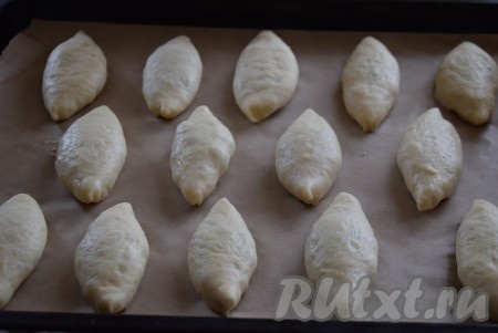 Таким образом лепим все пирожки. Выкладываем их на противень, застеленный пергаментом, швом вниз.
