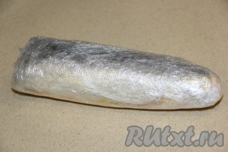 Сложить филе скумбрии с начинкой пополам так, чтобы начинка была внутри и плотно замотать в пищевую плёнку в несколько слоёв.
