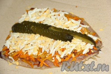 Маринованный огурец нарезать на длинные брусочки и выложить по середине филе.
