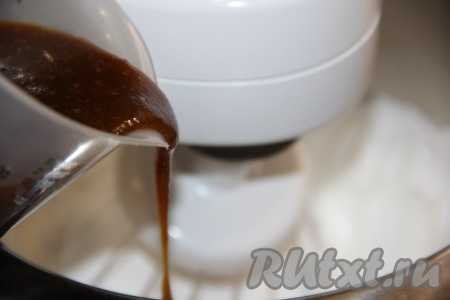 Продолжая взбивать, влить тонкой струйкой горячий сироп.
