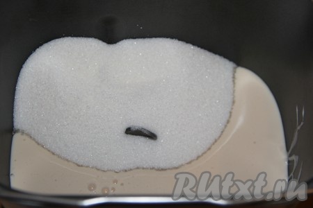 Я для замеса теста использовала хлебопечку, но в дальнейшем расскажу, как замесить его руками. В ведёрко хлебопечки нужно влить ряженку комнатной температуры и всыпать сахар.
