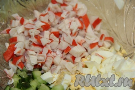 Крабовые палочки разморозить при комнатной температуре и мелко нарезать. В салатнике соединить нарезанные свежий огурец, крабовые палочки и варёные яйца.
