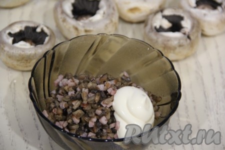 К обжаренным ножкам грибов с ветчиной добавить сметану и перемешать начинку.
