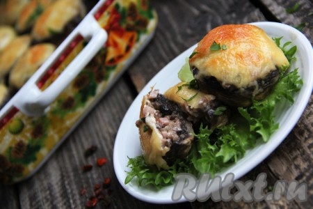 Форму с шляпками шампиньонов, фаршированными ветчиной и сыром, достать из духовки, переложить на тарелку и сразу подать к столу. Такая вкусная и сочная горячая закуска станет украшением стола и в будни, и в праздники!
