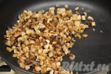 В сковороду влить масло, выложить мелко нарезанные грибные ножки, обжарить на среднем огне минут 5-7, помешивая время от времени.
