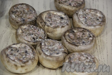 Выложить начинку в шляпки шампиньонов и утрамбовать.