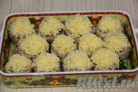 Поверх каждой фаршированной шляпки выложить сыр, натёртый на мелкой тёрке.
