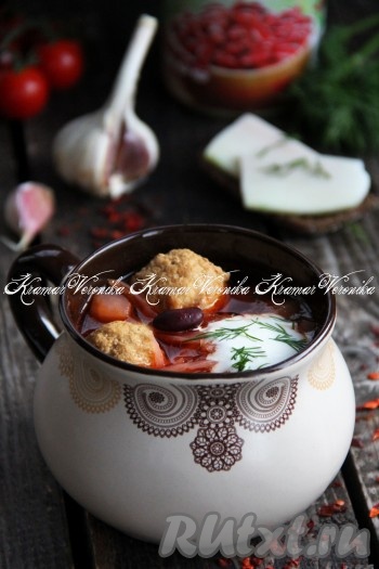 Вкусный, сытный, насыщенный сибирский борщ с фрикадельками и фасолью подать к столу со сметаной и зеленью.