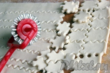 Покупное замороженное слоёное тесто немного раскатать в одном направлении и нарезать на небольшие прямоугольнички, интереснее - фигурные.