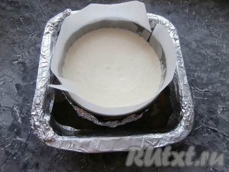 В противень с бортиками (или в подходящую форму) поместить разъёмную форму с творожной смесью. В противень с бортиками влить столько горячей воды, чтобы она доходила до половины разъёмной формы с творожной смесью.
