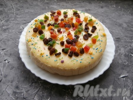 Далее форму с остывшей творожной пасхой достать из духовки и поместить в холодильник, как минимум, на 3-4 часа и только после этого аккуратно извлечь из формы. Переложить пасху на тарелку, украсить цукатами, изюмом и цветной посыпкой.
