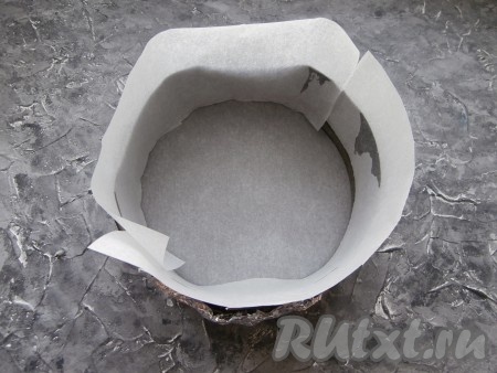 Дно и бока разъёмной формы диаметром 18-20 см застелить пергаментом. Снаружи дно и бока формы до половины завернуть фольгой, сложенной в 2-3 раза (на фото практически не видно фольги, так как она находится снаружи формы). Фольга нужна, чтобы творожная масса не стала вытекать из разъёмной формы во время выпекания в духовке.
