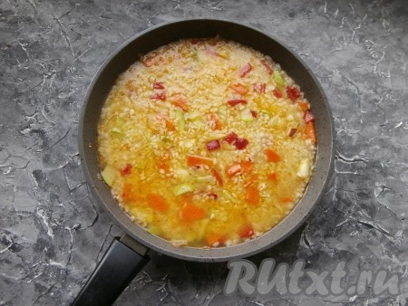Перемешать, рис разровнять, накрыть сковороду крышкой.
