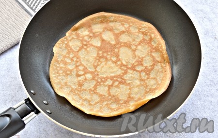 Дно сковороды (у меня диаметр сковородки 18 см) смазать маслом перед жаркой первого блинчика. Хорошо раскалить поверхность сковороды на огне. Набрать с помощью половника тесто, влить его на разогретую сковороду, равномерно распределяя по дну. Жарить каждый блинчик, приблизительно, по 40 секунд с каждой стороны на умеренном огне. Пока жарится блин, само блинное тесто в миске нужно периодически перемешивать, чтобы оно не застаивалось. После выпечки первого блина сковороду можно уже не смазывать маслом, так как мы добавили его в само блинное тесто.
