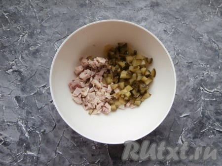 Куриное мясо нужно отварить в подсоленной воде до готовности (варить с момента закипания воды минут 40), остудить. Если мясо с костями, отделить его от косточек. Я отварила окорочок. Мясо нарезать небольшими кусочками, выложить в достаточно глубокую миску, добавить нарезанные на небольшие кубики маринованные огурцы.
