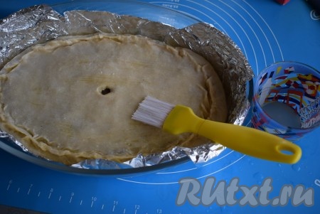 Смазываем содовым раствором заготовку пирога при помощи кулинарной кисти.
