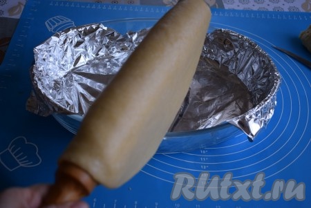 Накручиваем больший пласт теста на скалку и легко переносим его таким способом, выкладываем на дно формы.
