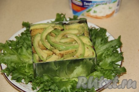 Авокадо почистить от кожуру, удалить косточку. Нарезать мякоть авокадо тонкими дольками и выложить поверх рыбы.
