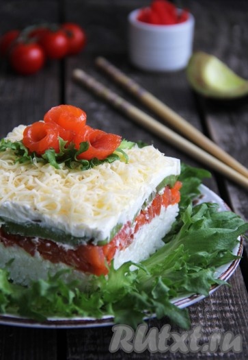 Верхушку салата, выложенного слоями, украсить кусочками рыбы и веточками зелени. Очень вкусный, красивый, нежнейший салат "Суши", приготовленный с красной рыбой и авокадо, подать к столу. При подаче можно полить соевым соусом.