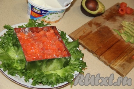 Следующим слоем выложить равномерно нарезанную красную рыбу и разровнять. Я оставила немного рыбы для украшения верхушки салата. Смазать рыбный слой творожным сыром.

